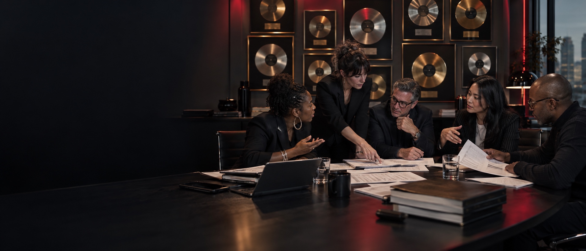 Music publishing team in an animated rights and licensing meeting in front of gold and platinum records